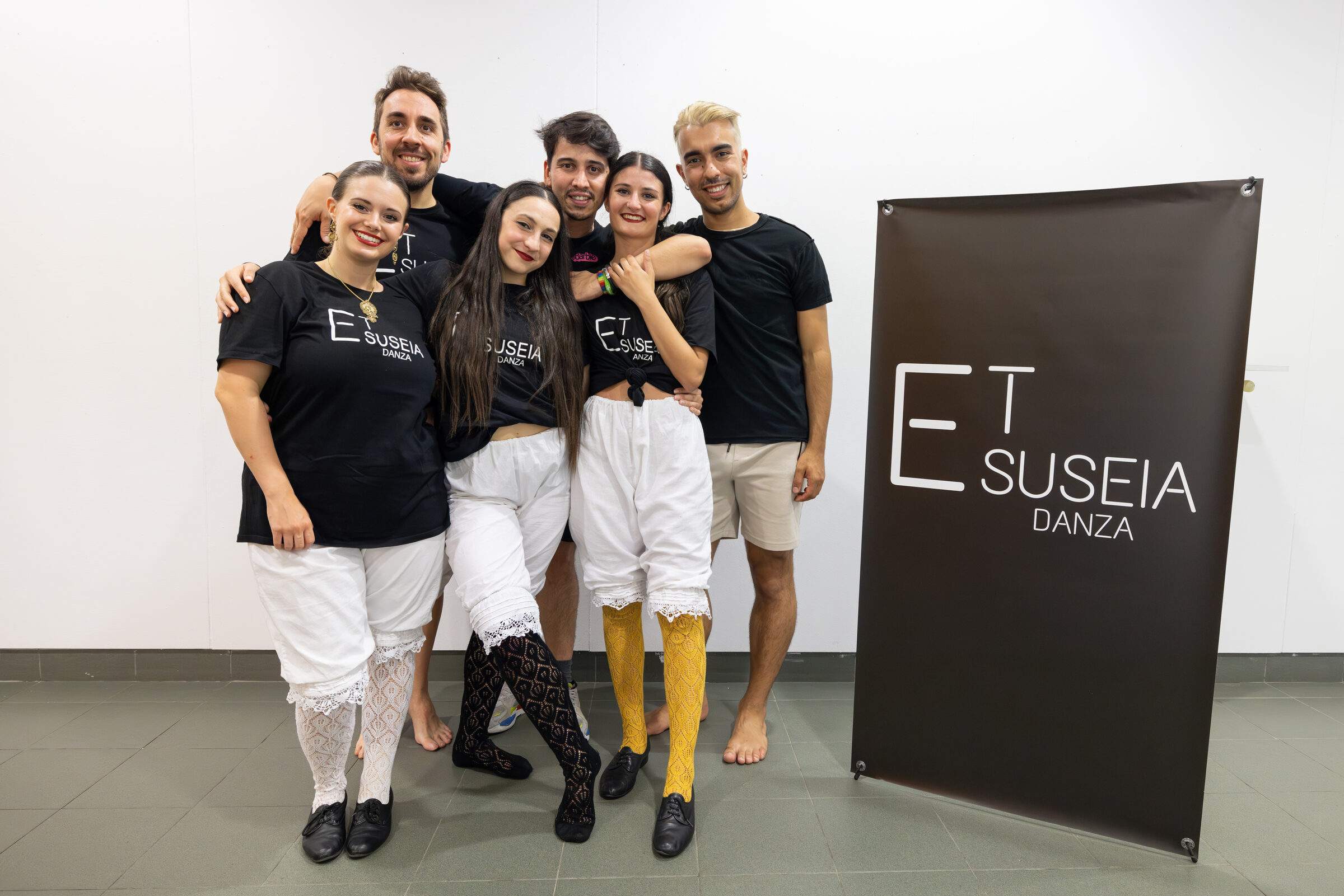 Equipo da compañía Et Suseia Danza xunto ao cartel da compañía